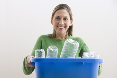 Workers handling commercial waste containers with PPE